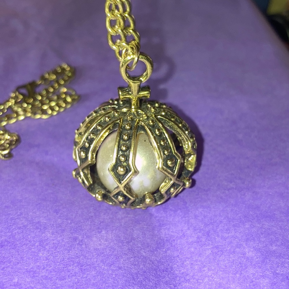Pearl in a cage brass tone necklace